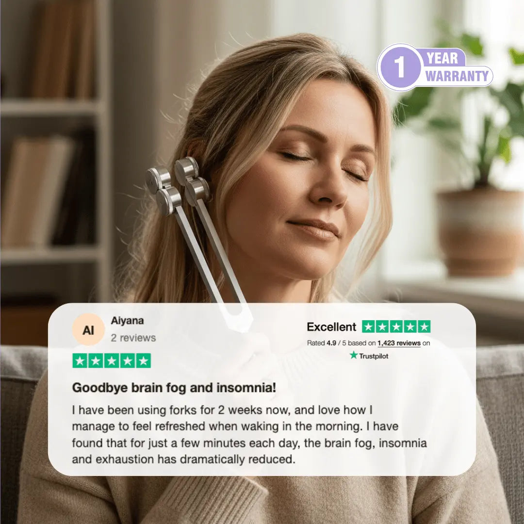 Woman using a weighted 64 Hz tuning fork near her ear for calming vibration therapy and nervous system relaxation