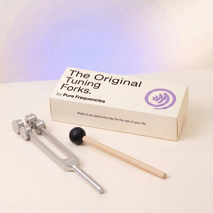 64 Hz tuning fork and mallet with 'The Original Tuning Forks by Pure Frequencies' packaging on a light background